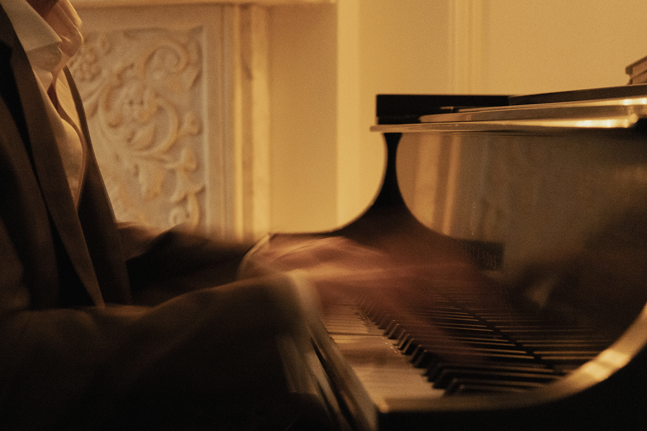 A candlelit salon gathering with a cellist performing