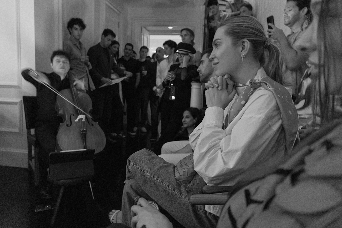 Guests listening intently to a cellist in a private salon